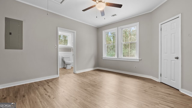 unfurnished bedroom with multiple windows, crown molding, electric panel, and light hardwood / wood-style flooring