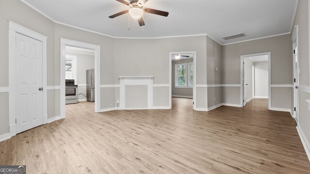 spare room featuring crown molding, ceiling fan, and light wood-type flooring