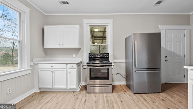 kitchen with white cabinetry, appliances with stainless steel finishes, a healthy amount of sunlight, and light wood-type flooring