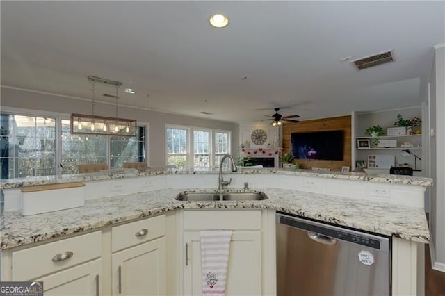 kitchen with sink, dishwasher, light stone countertops, white cabinets, and decorative light fixtures