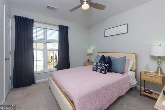 carpeted bedroom featuring multiple windows and ceiling fan