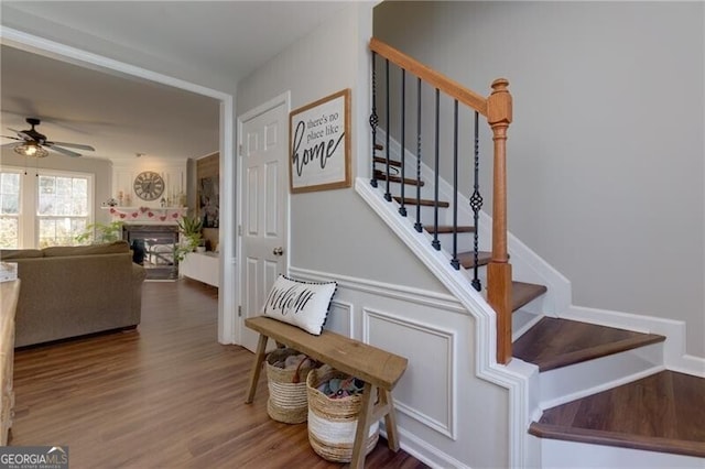 stairs featuring hardwood / wood-style flooring and ceiling fan