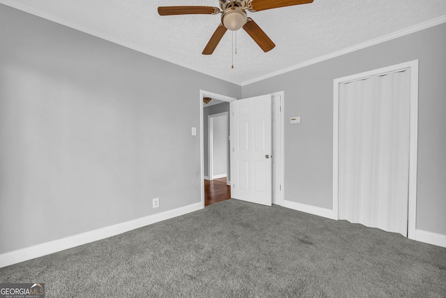 unfurnished bedroom featuring crown molding, ceiling fan, dark colored carpet, a textured ceiling, and a closet