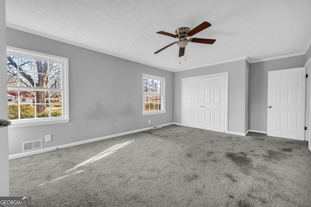 unfurnished bedroom featuring carpet floors, ceiling fan, crown molding, a textured ceiling, and a closet