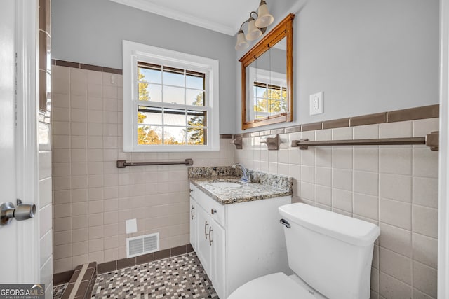 bathroom with vanity, ornamental molding, tile walls, and toilet