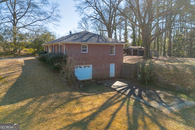 view of side of home featuring a garage and a yard