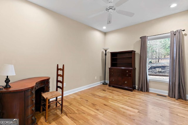 home office with ceiling fan and light hardwood / wood-style flooring