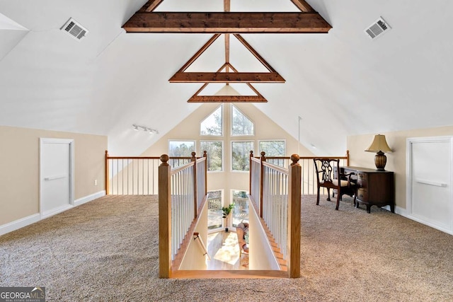 interior space featuring carpet flooring and lofted ceiling with beams