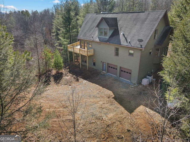 rear view of property with a garage and a deck