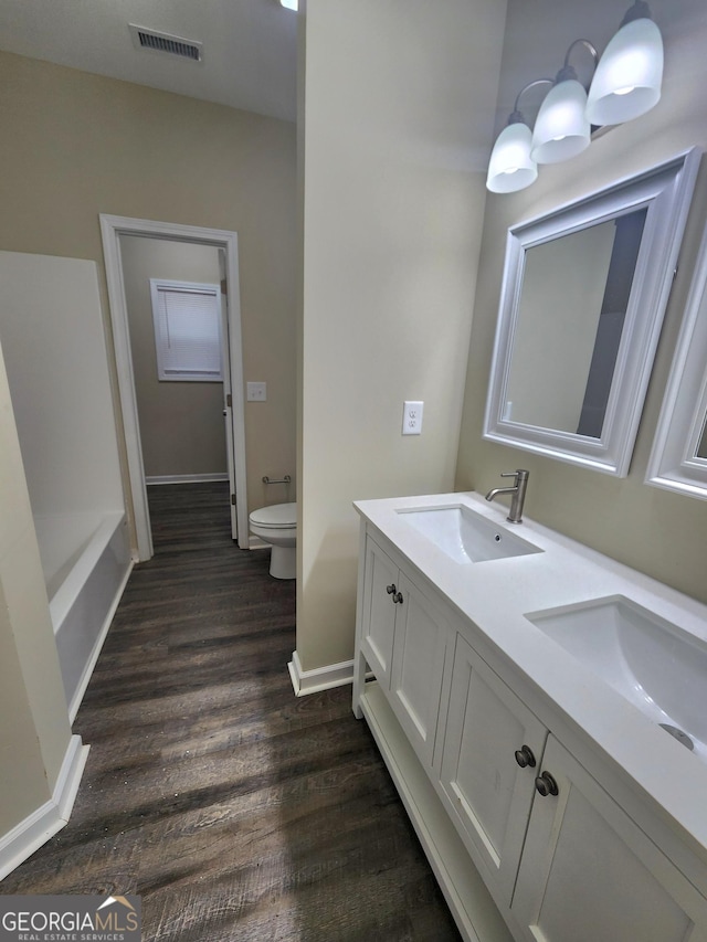 bathroom featuring hardwood / wood-style flooring, vanity, and toilet