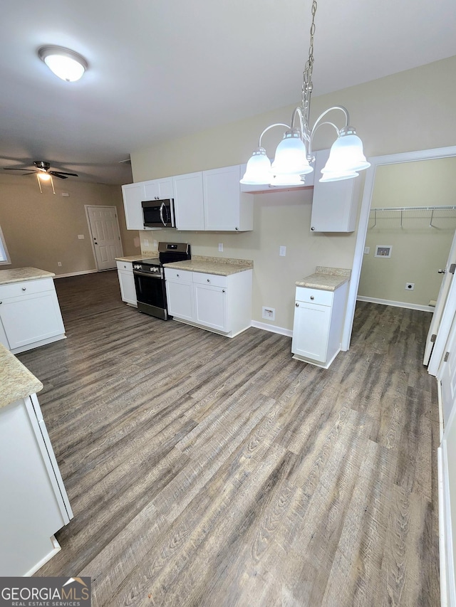 kitchen with hanging light fixtures, dark hardwood / wood-style floors, white cabinets, and appliances with stainless steel finishes