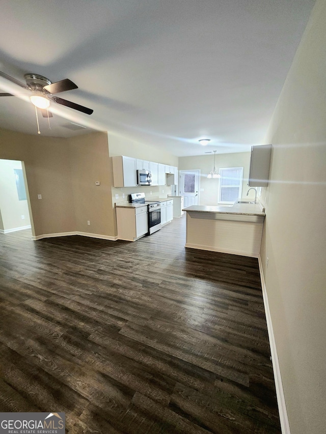 unfurnished living room featuring dark wood-type flooring and ceiling fan