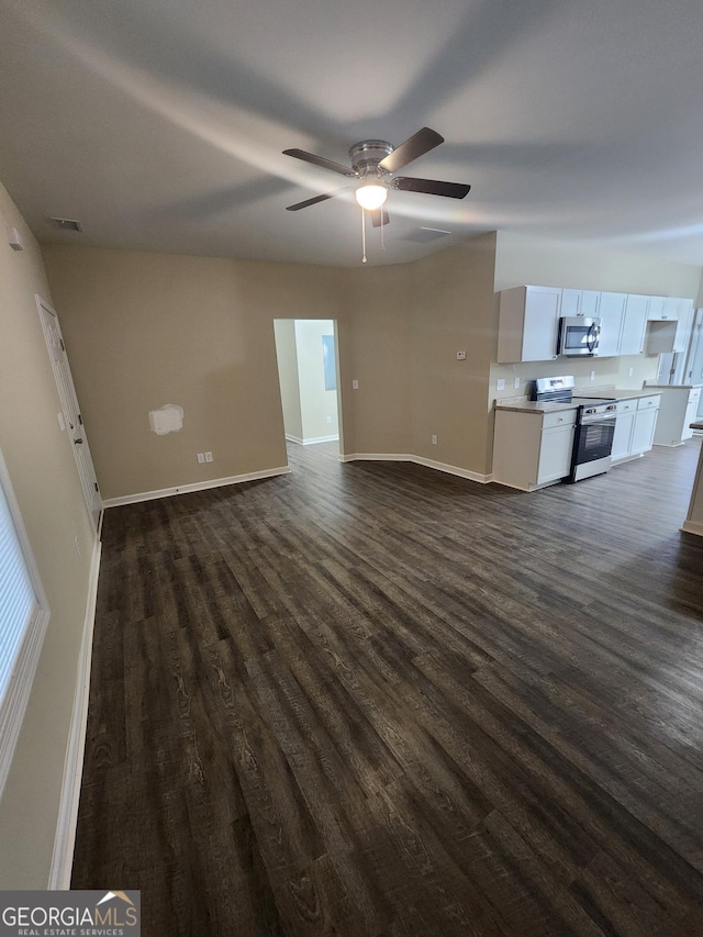 unfurnished living room featuring dark wood-type flooring and ceiling fan