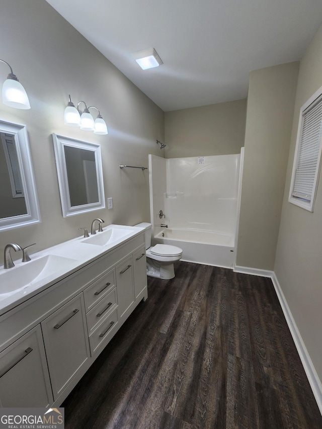 full bathroom with vanity, hardwood / wood-style flooring, bathtub / shower combination, and toilet