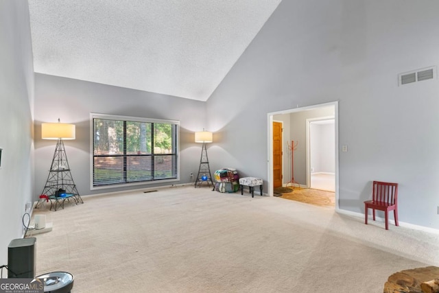 carpeted living room featuring high vaulted ceiling and a textured ceiling