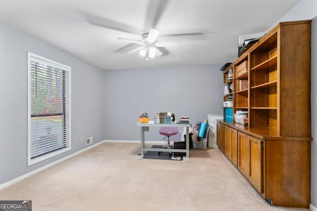 carpeted home office featuring ceiling fan