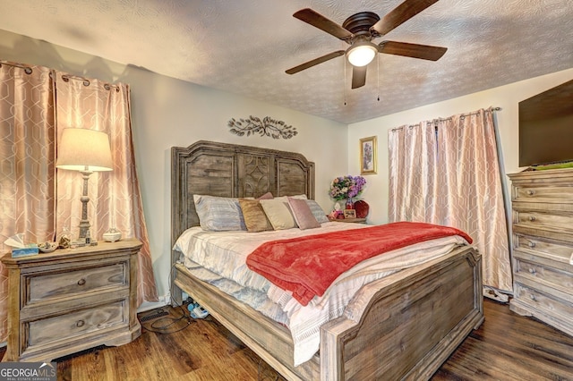 bedroom featuring ceiling fan, dark wood-type flooring, and a textured ceiling