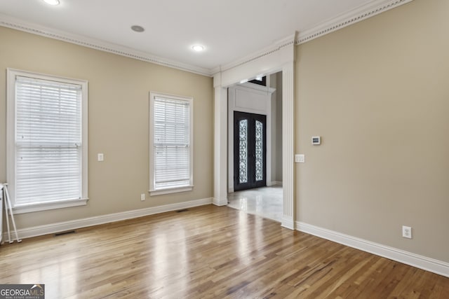 spare room featuring light hardwood / wood-style flooring and ornamental molding