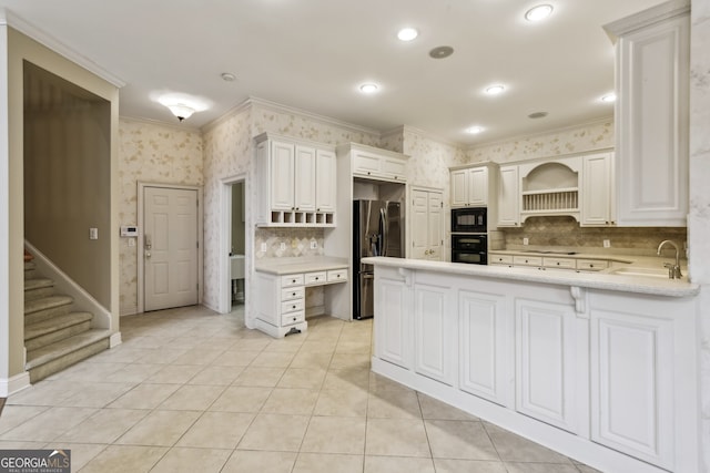 kitchen with white cabinetry, sink, black appliances, and kitchen peninsula