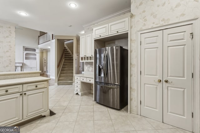 kitchen with crown molding, light tile patterned floors, and stainless steel fridge