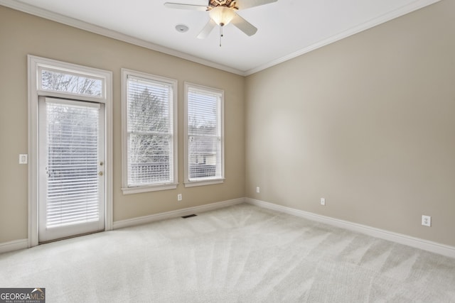 spare room featuring ornamental molding, light carpet, and ceiling fan