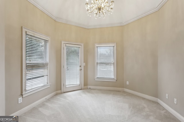 carpeted spare room featuring crown molding and a notable chandelier