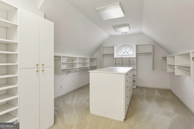 spacious closet featuring vaulted ceiling and light colored carpet