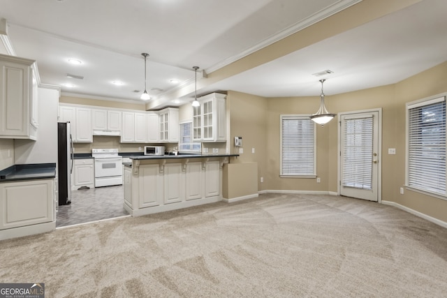 kitchen featuring stainless steel refrigerator, white range with electric cooktop, white cabinetry, hanging light fixtures, and kitchen peninsula