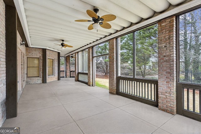 unfurnished sunroom with ceiling fan and a wealth of natural light