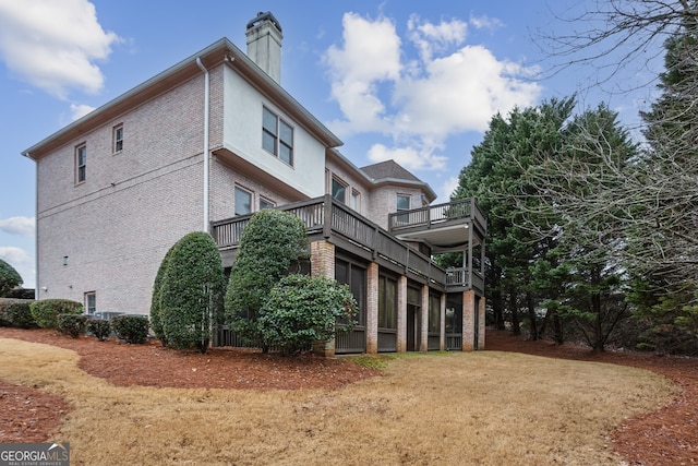 view of property exterior with a balcony and a lawn