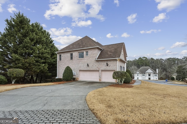 view of side of property with a garage and a lawn