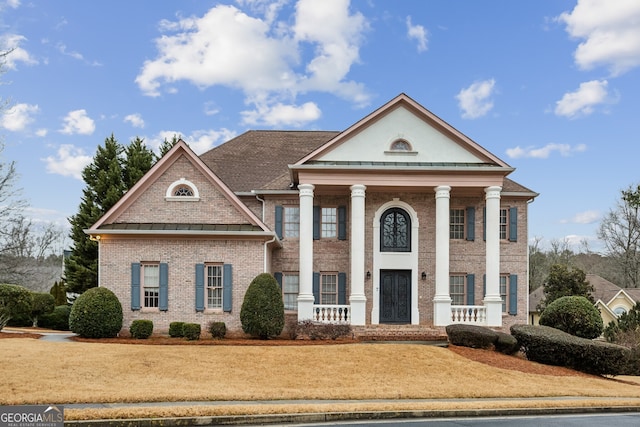 greek revival inspired property with a porch and a front lawn