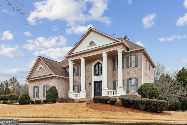 greek revival house featuring a front yard