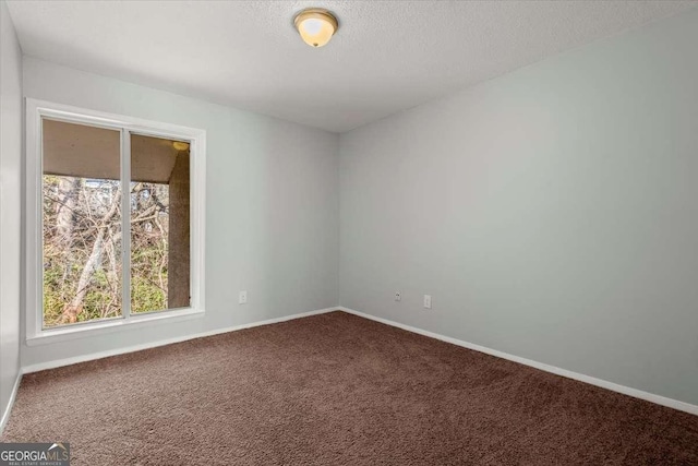 carpeted spare room featuring a textured ceiling