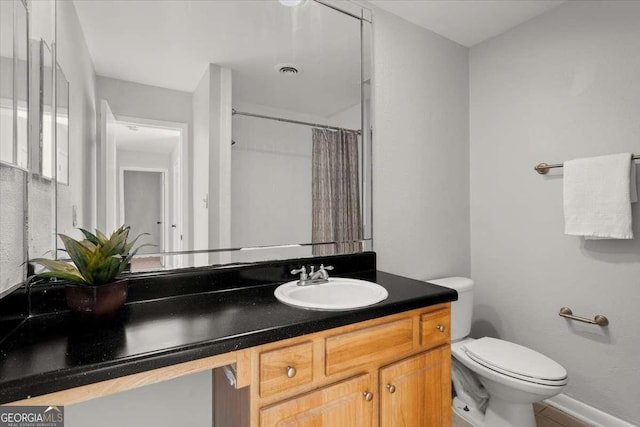 bathroom with vanity, curtained shower, and toilet