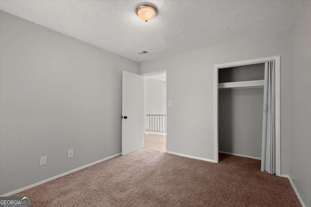 unfurnished bedroom featuring a closet, a textured ceiling, and carpet flooring