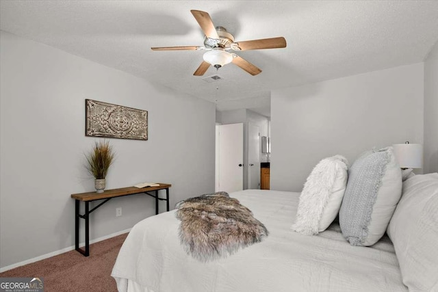 bedroom featuring light carpet, ceiling fan, and a textured ceiling