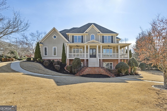 view of front of property featuring ceiling fan, covered porch, and a front lawn