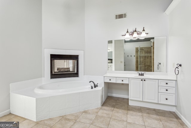 bathroom featuring independent shower and bath, vanity, a high ceiling, and tile patterned floors