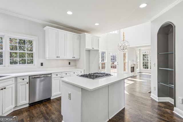 kitchen with white cabinetry, a center island, ornamental molding, dark hardwood / wood-style floors, and stainless steel appliances