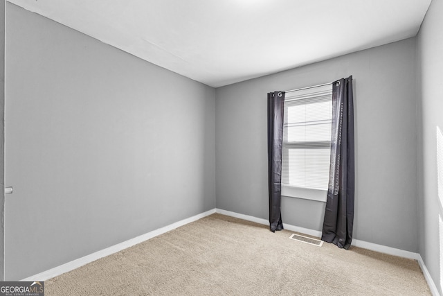 spare room featuring light colored carpet