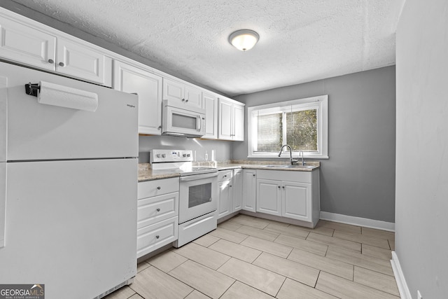 kitchen with sink, a textured ceiling, white cabinets, and white appliances