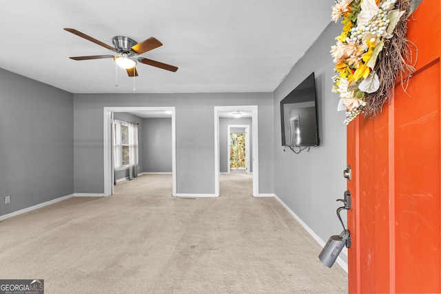 interior space featuring light colored carpet and ceiling fan