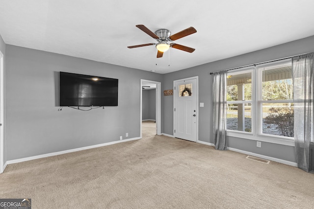 unfurnished living room featuring light carpet and ceiling fan