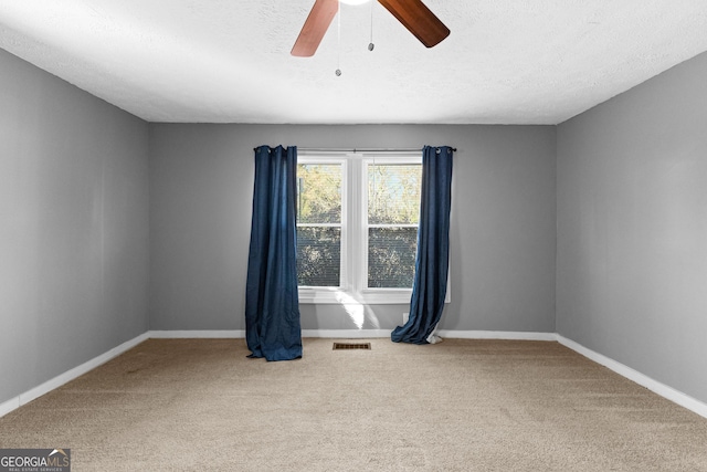 spare room featuring ceiling fan, carpet, and a textured ceiling