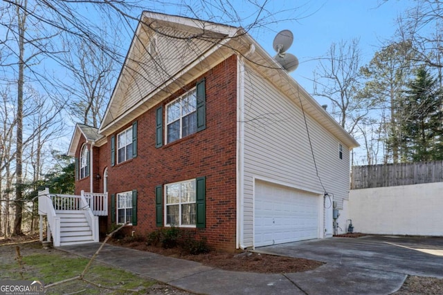 view of side of property featuring brick siding, driveway, and a garage