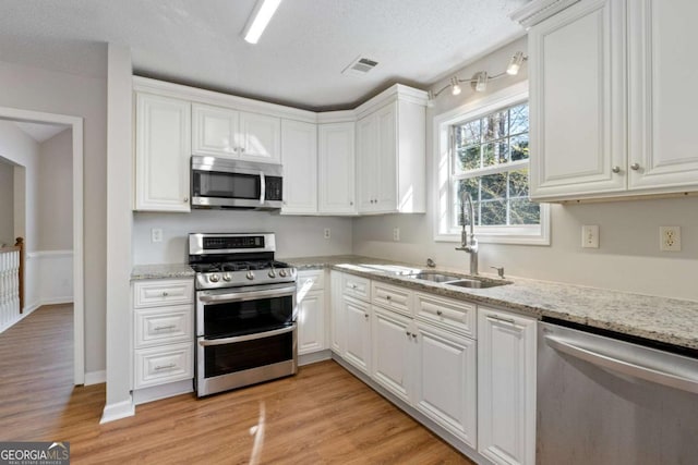 kitchen featuring a sink, light wood-style flooring, visible vents, and stainless steel appliances