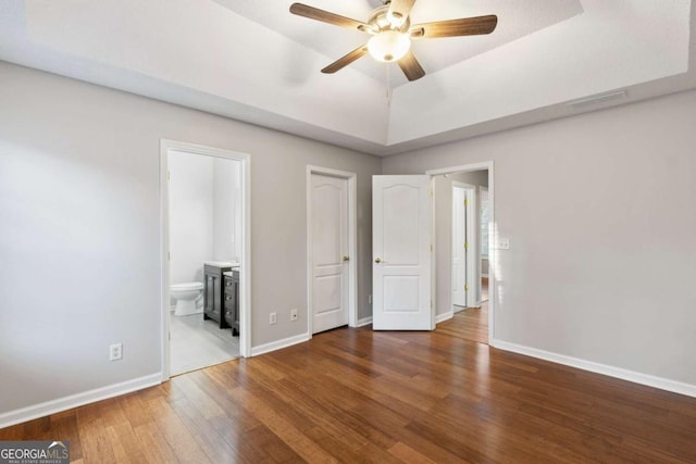 spare room with a raised ceiling, wood-type flooring, a textured ceiling, and ceiling fan