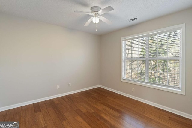 unfurnished room with visible vents, baseboards, wood finished floors, a textured ceiling, and a ceiling fan