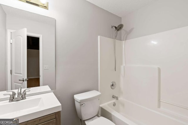 bathroom with a textured ceiling, toilet, shower / bathing tub combination, and vanity